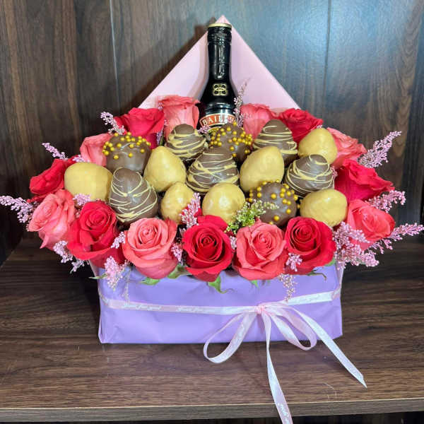 Box arrangement of red and pink roses with chocolates and a Baileys bottle