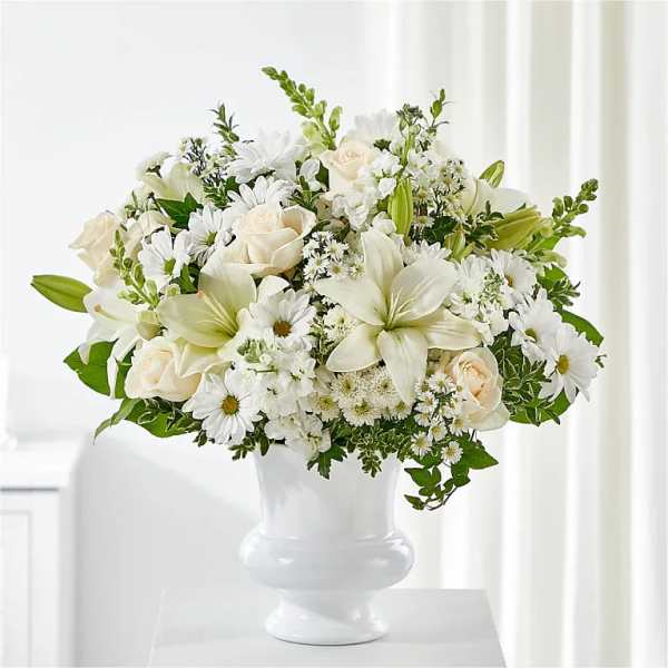 White floral arrangement in a white pedestal vase