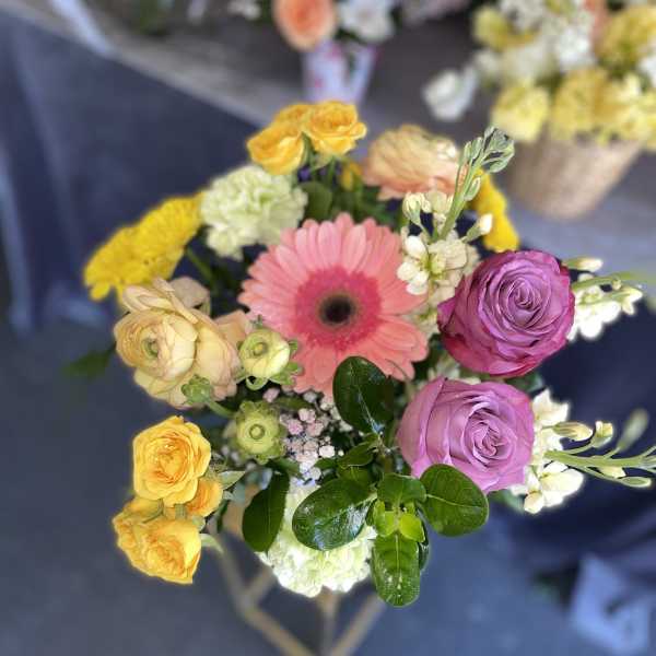 Mixed bouquet with pink gerbera, purple roses, and yellow blooms