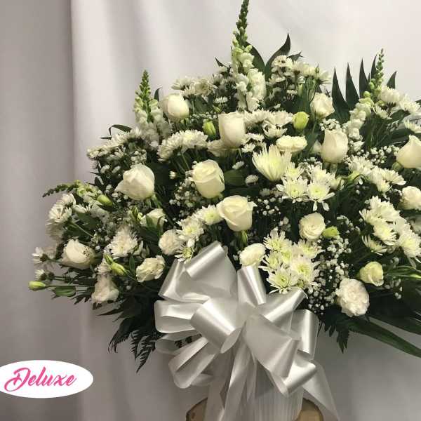 White floral spray with roses and daisies, finished with a silver bow