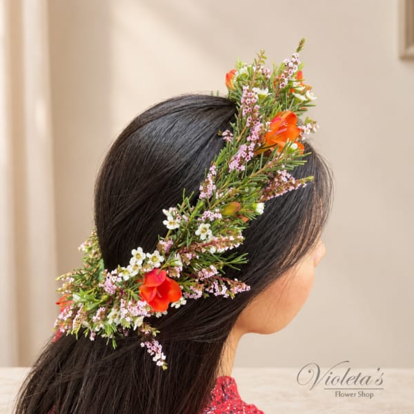 Woman wearing a floral crown with orange and white blossoms