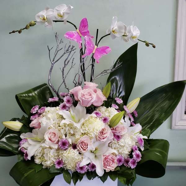 Pink roses and white lilies with orchids in a floral arrangement