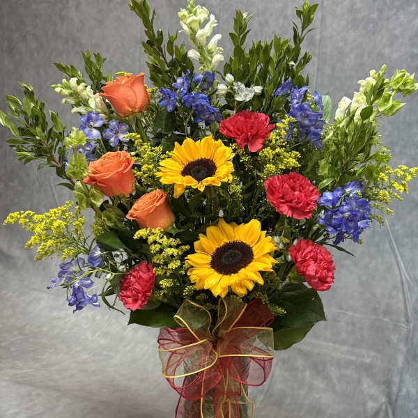 Colorful mixed bouquet in a glass vase with ribbon