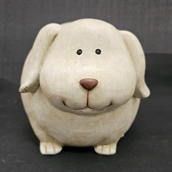 Ceramic dog figurine with a rounded face and small black eyes