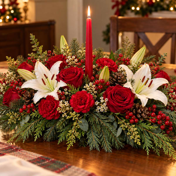 Red roses and white lilies arranged around a red taper candle