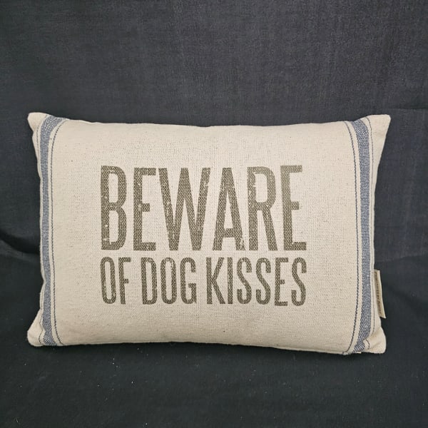 Decorative pillow with the words "BEWARE OF DOG KISSES"