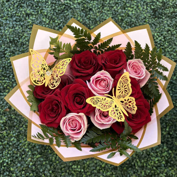 Bouquet of red and pink roses with gold butterfly decorations