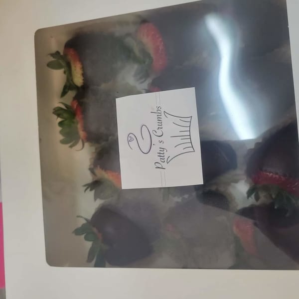 Box of chocolate-dipped strawberries with pink and white decoration