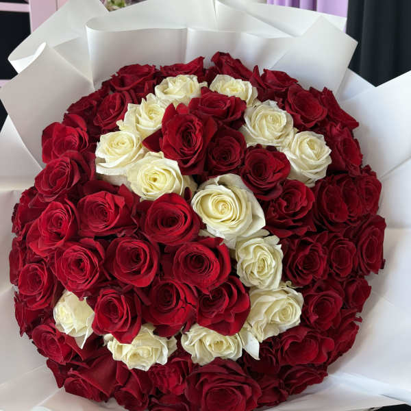 Bouquet of red and white roses wrapped in white paper