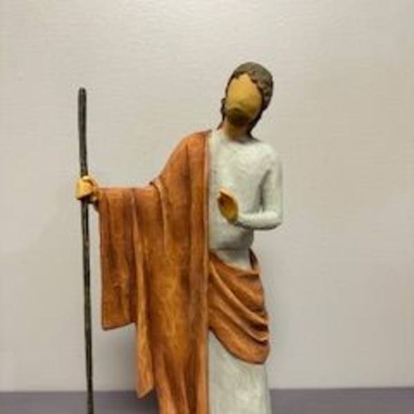 Small figurine of a robed person holding a staff