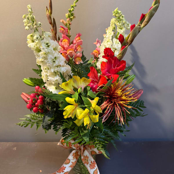 Colorful mixed bouquet with tall blooms in a vase