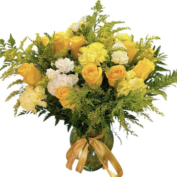 Yellow roses and white carnations in a glass vase with a ribbon