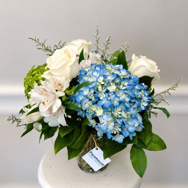 Blue hydrangeas and white roses in a glass vase