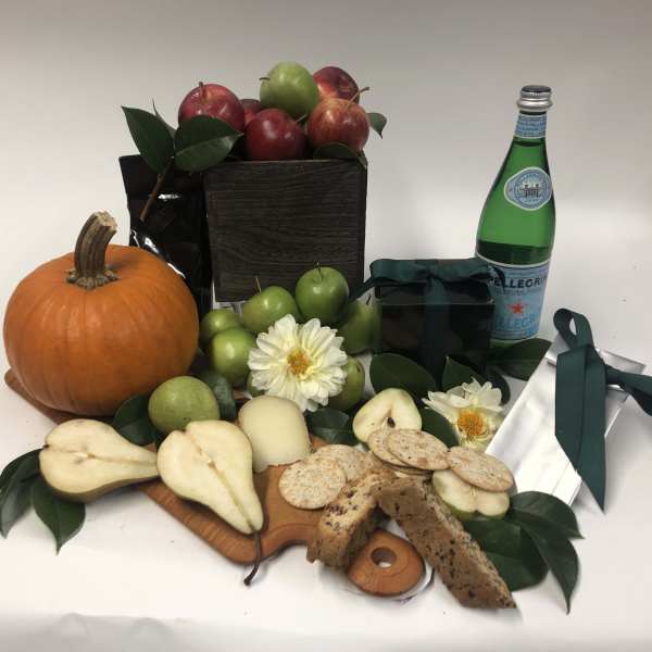 Fruit and snack gift arrangement with a pumpkin and flowers