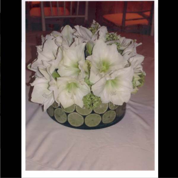 White amaryllis bouquet in a round vase with lime slices