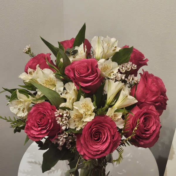 Pink roses and white lilies arranged in a clear glass vase