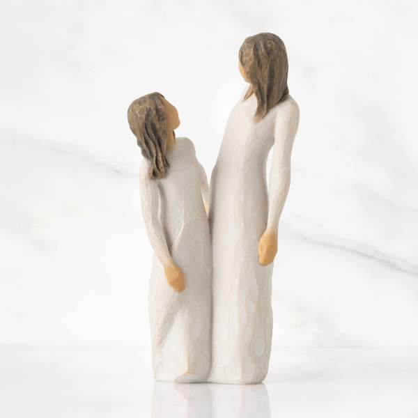 Two carved figurines of a woman and child in white robes