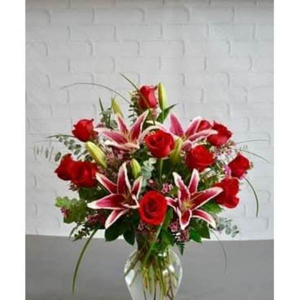 Red roses and pink lilies arranged in a clear glass vase