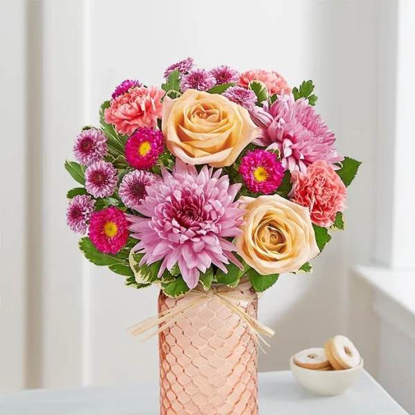 Pink and peach flower arrangement in a textured vase