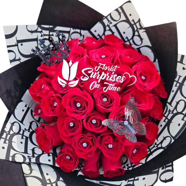 Bouquet of bright red roses with decorative butterflies and a crown topper