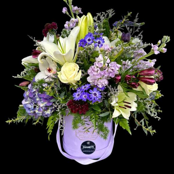 Lavender hatbox arrangement with lilies, roses, and purple daisies