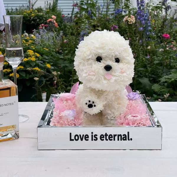 White floral dog sculpture in a mirrored box with pink flowers