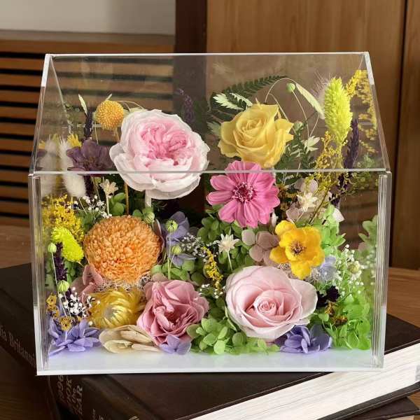 Mixed flowers arranged in a clear acrylic box