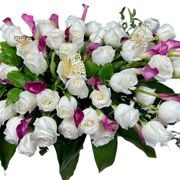 White roses and magenta calla lilies in a low arrangement