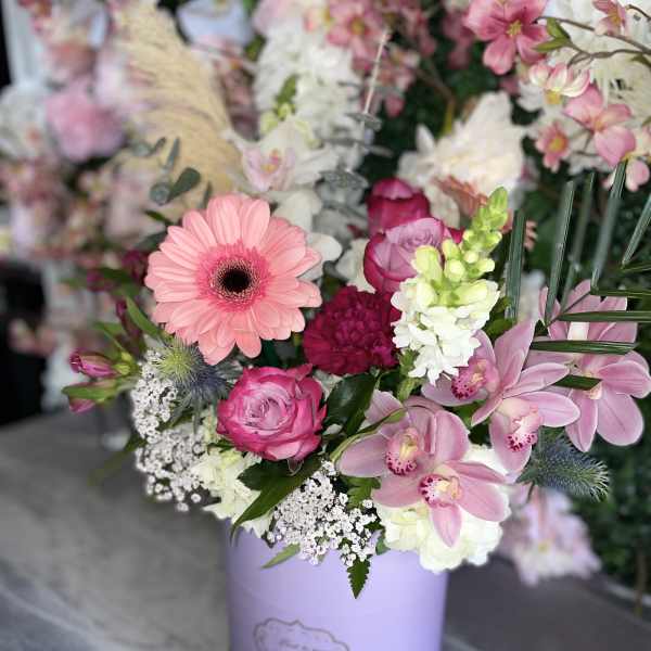 Pink and white mixed flower arrangement in a lavender box