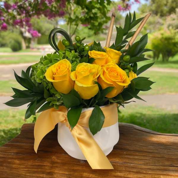 Yellow roses in a white hatbox with a satin ribbon