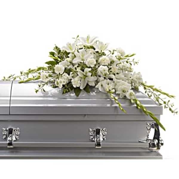White floral casket spray on a silver casket