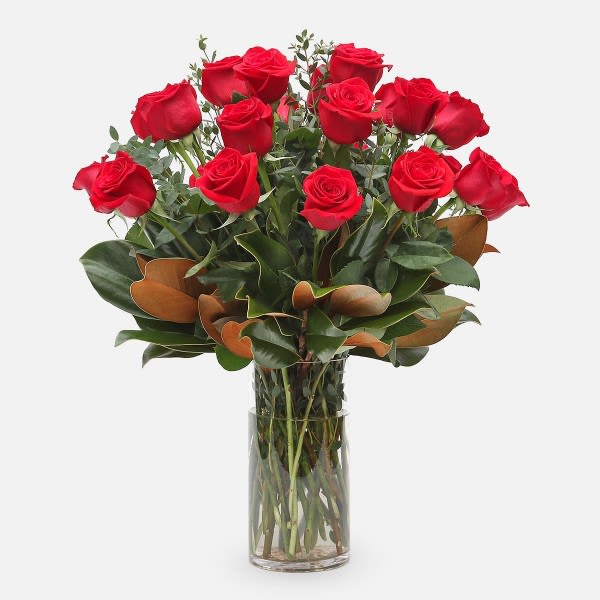 Red roses arranged in a clear glass vase