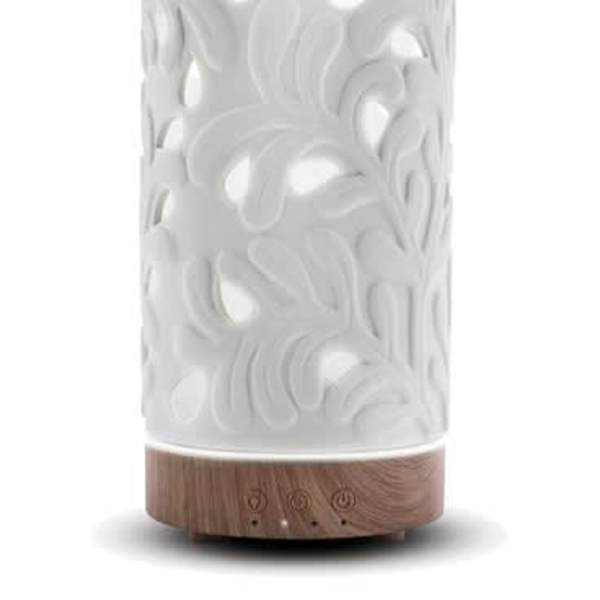 White carved diffuser with glowing cutout pattern and wood-look base