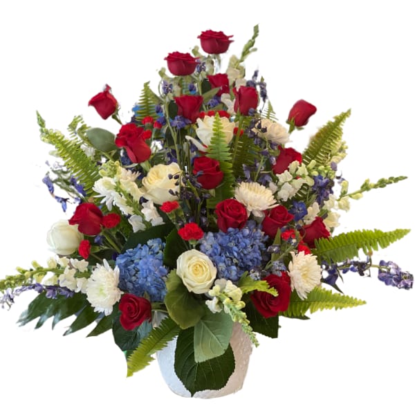 Mixed bouquet of red and white roses with blue hydrangeas in a white vase