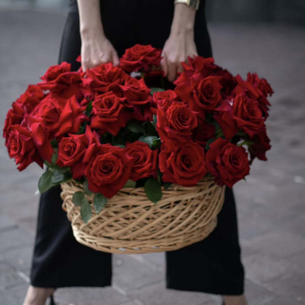 Basket of red roses held by a person