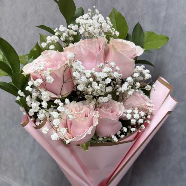 Pink roses with white baby's breath in pink wrapping