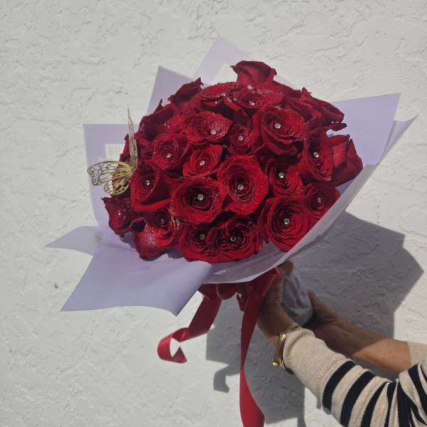 Bouquet of red roses wrapped in pale lavender paper with a red ribbon