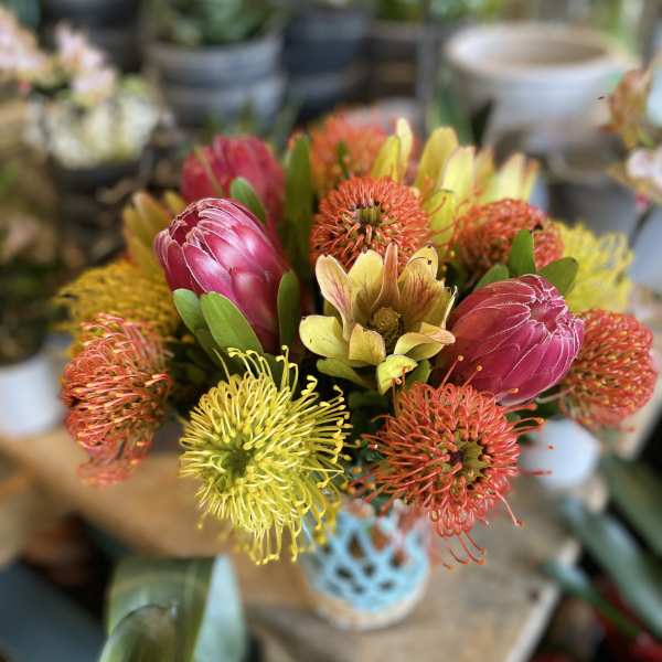Bouquet of pink protea and yellow-orange pincushion flowers