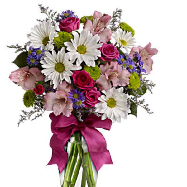 Bouquet of daisies, roses, and pink lilies in a glass vase