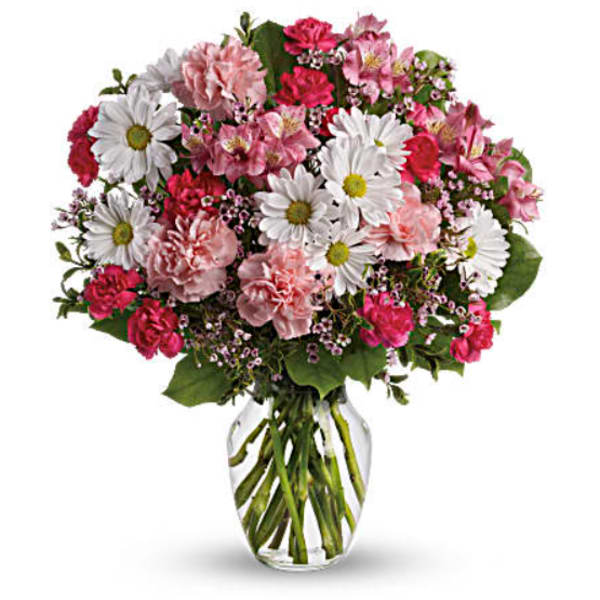 Mixed pink and white flowers arranged in a clear glass vase