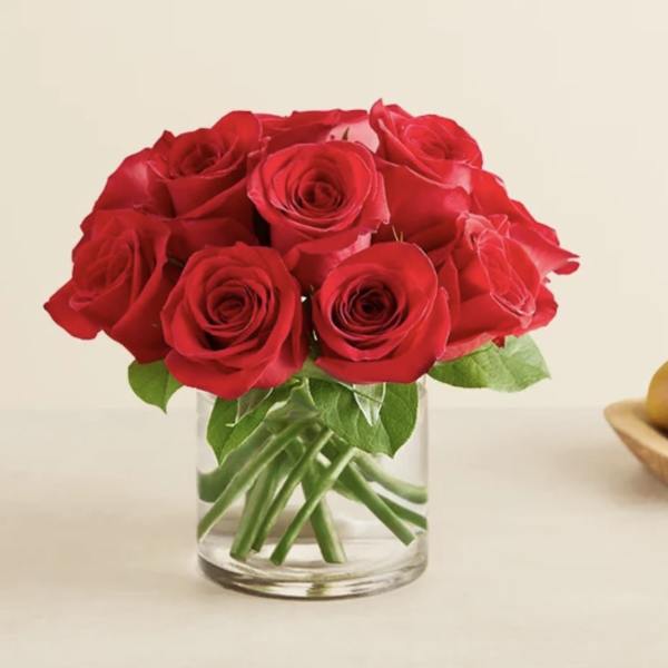 Red roses arranged in a clear glass vase
