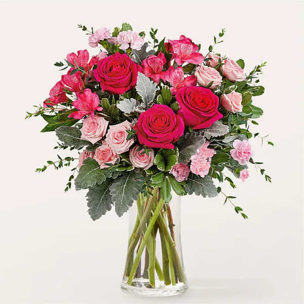 Pink roses and carnations in a clear glass vase