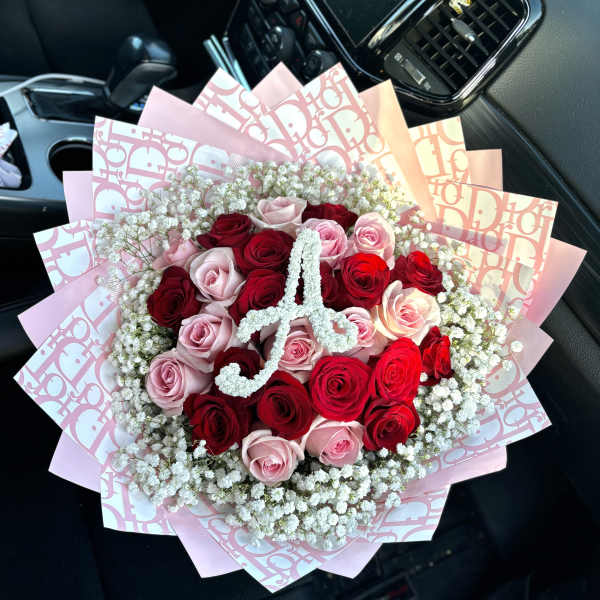 Bouquet of red and pink roses with baby's breath in pink wrapping