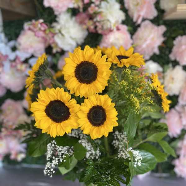 Sunflower bouquet in a clear glass vase with white filler flowers