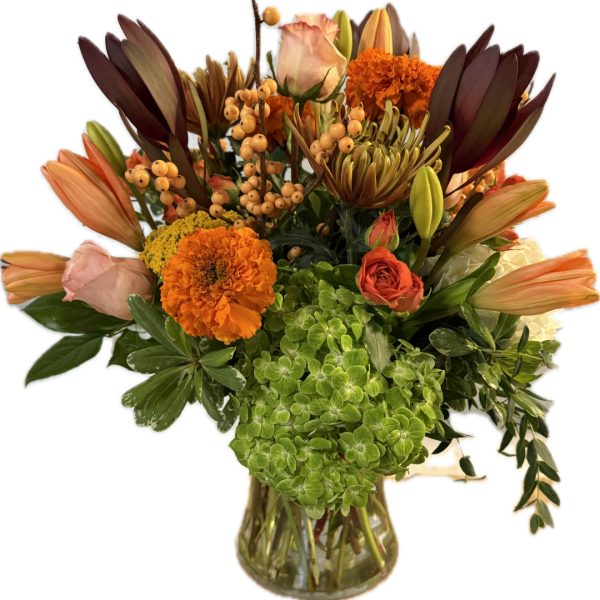 Mixed bouquet of orange, peach, and green flowers in a glass vase