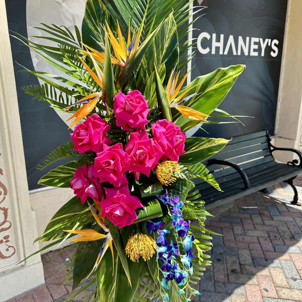 Tall tropical arrangement with pink roses and orchids
