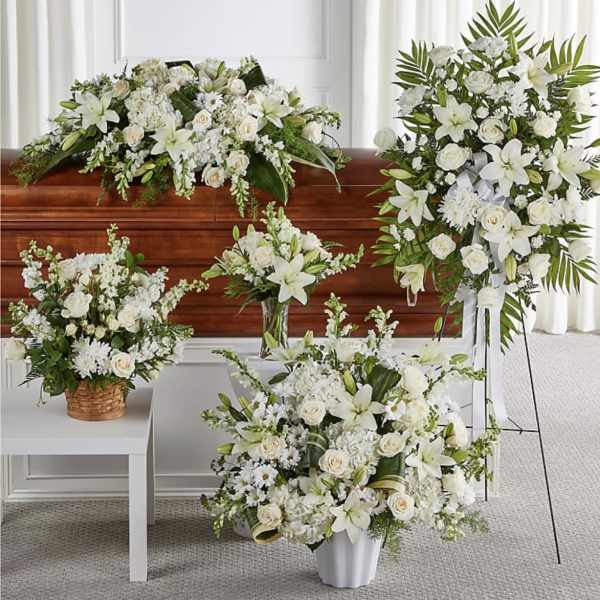 White floral funeral arrangements displayed around a casket