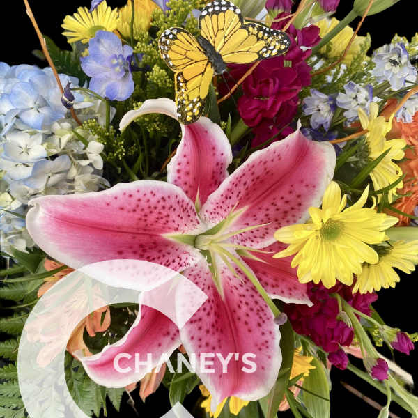 Colorful bouquet with a large pink lily and a butterfly accent