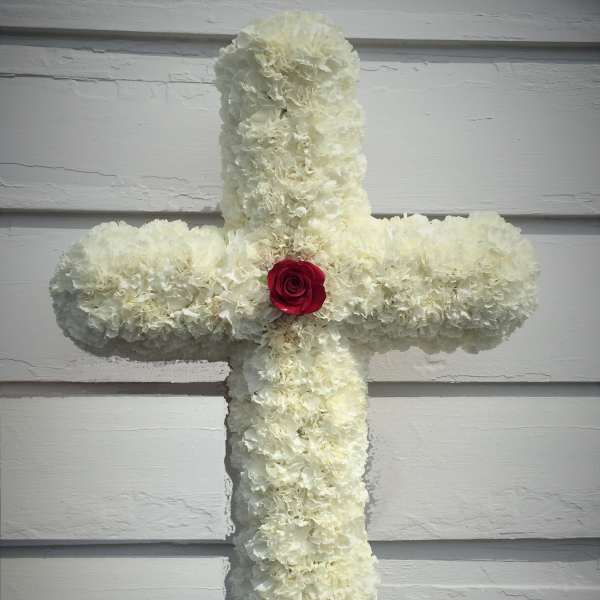 White floral cross with a red rose at the center
