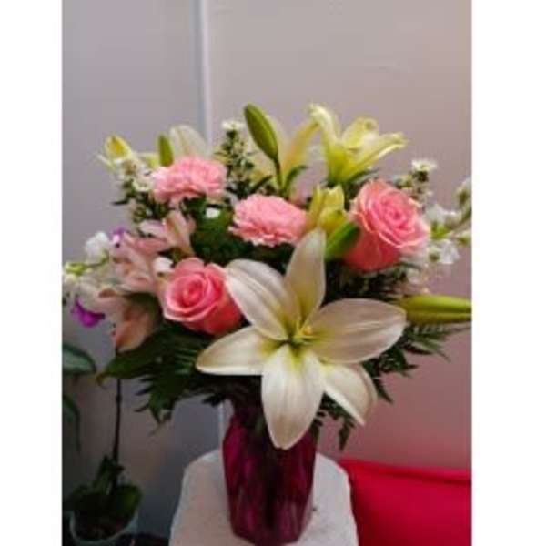 Bouquet of pink roses and white lilies in a glass vase